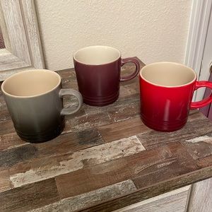 3 Le Creuset coffee mugs purple, grey, red new with tags. Has some small marks.